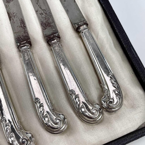 110 - A George V silver cased set of leaf scroll pistol filled handled butter knives Maker GHB, Sheffield ... 