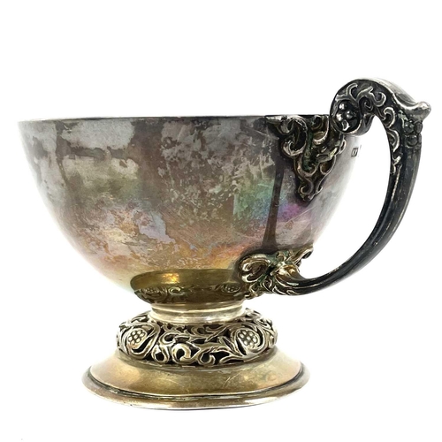 20 - A George V Irish silver pedestal cup by Mappin & Webb. Of plain form the foliate cast handle with sc... 