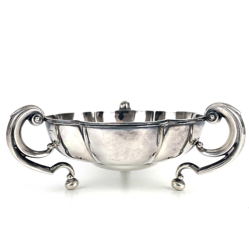 50 - An Edwardian silver lobed triple handled dish by Mappin & Webb. With flying scroll handles on ball f... 