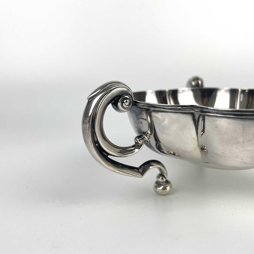 50 - An Edwardian silver lobed triple handled dish by Mappin & Webb. With flying scroll handles on ball f... 