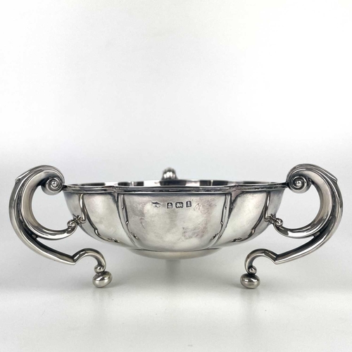 50 - An Edwardian silver lobed triple handled dish by Mappin & Webb. With flying scroll handles on ball f... 