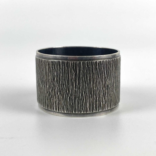 58 - A modern silver heavy napkin ring with textured design by Mappin & Webb. London 1971; together with ... 