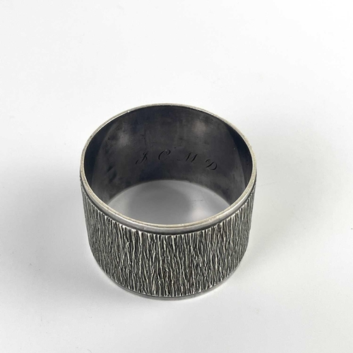 58 - A modern silver heavy napkin ring with textured design by Mappin & Webb. London 1971; together with ... 