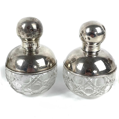 73 - A pair of George V silver mounted cut glass ovoid scent bottles. London 1920, height 11cm; together ... 