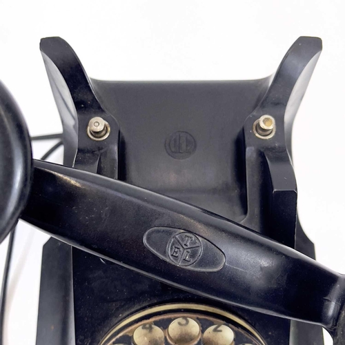 112 - An AEP black Bakelite telephone. Dated 1957, length 19cm.