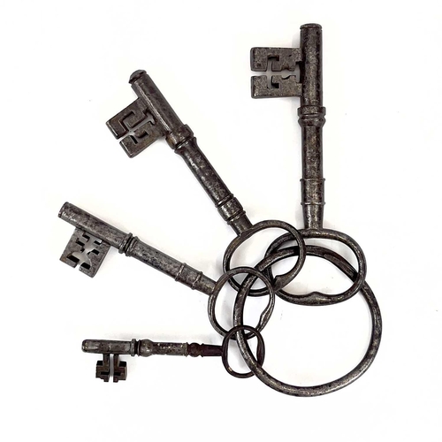 114 - A group of four large Georgian steel keys on a ring. The largest length 14.5cm, together with a set ... 