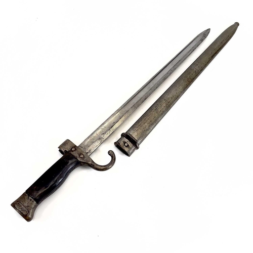 115 - A WWI bayonet and scabbard. With a 40cm straight single fullered blade, downturned quillon, numbered... 