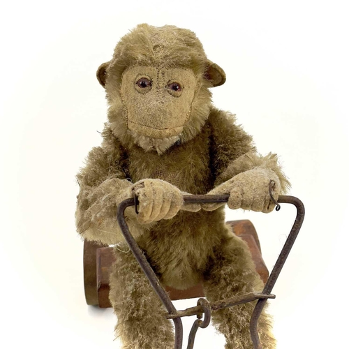 13 - A 1930s plush monkey on a cart probably Steiff. With wrought iron frame and wood seat and wheels, le... 