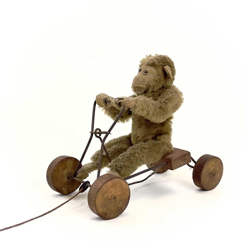 13 - A 1930s plush monkey on a cart probably Steiff. With wrought iron frame and wood seat and wheels, le... 