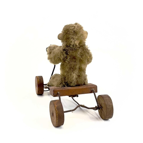 13 - A 1930s plush monkey on a cart probably Steiff. With wrought iron frame and wood seat and wheels, le... 