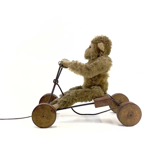 13 - A 1930s plush monkey on a cart probably Steiff. With wrought iron frame and wood seat and wheels, le... 