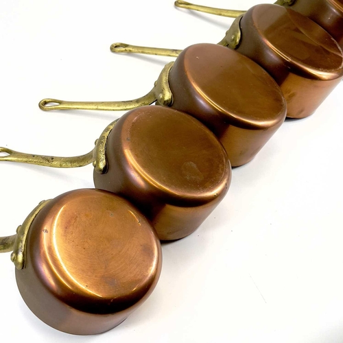 142 - A graduated set of five copper pans. Diameter of largest pan 20cm.