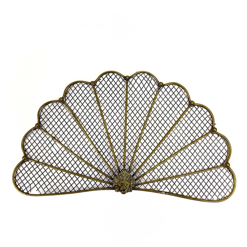 154 - A victorian brass fan shape spark guard. Centering a lion mask, the mesh with rod supports, height 3... 