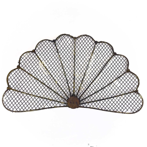 154 - A victorian brass fan shape spark guard. Centering a lion mask, the mesh with rod supports, height 3... 