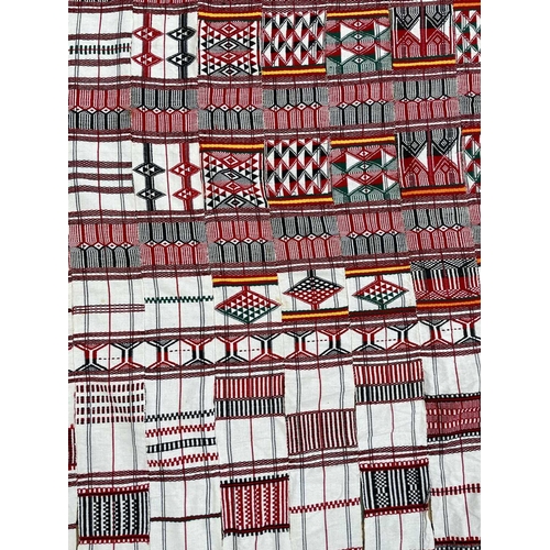 1611 - A cotton African textile with geometric designs. 135cm x 230cm, together with two other African text... 