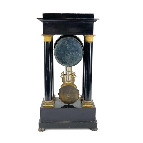 1709 - A French ebonised and ormolu portico clock. 19th century, with gilt capped tapered column supports, ... 