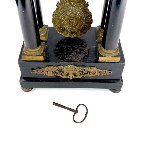 1709 - A French ebonised and ormolu portico clock. 19th century, with gilt capped tapered column supports, ... 