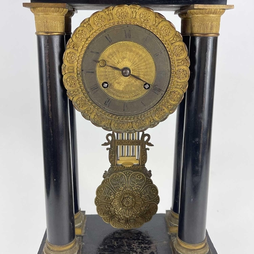 1709 - A French ebonised and ormolu portico clock. 19th century, with gilt capped tapered column supports, ... 