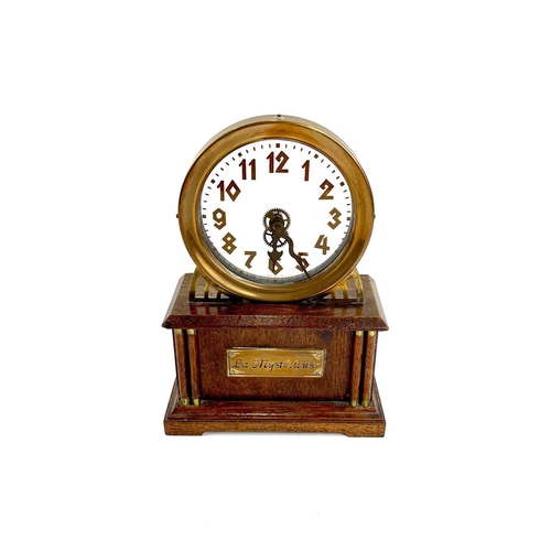 1713 - An American La Mysterieuse oak and brass cased mystery mantel clock. Circa 1910, the glass dial with... 