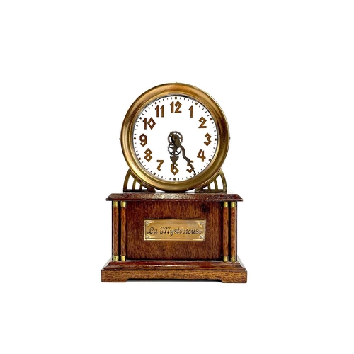 1713 - An American La Mysterieuse oak and brass cased mystery mantel clock. Circa 1910, the glass dial with... 