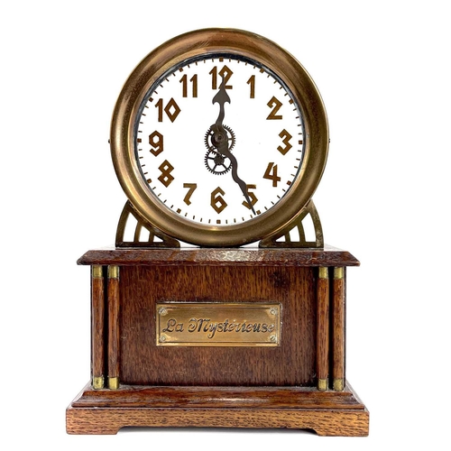 1713 - An American La Mysterieuse oak and brass cased mystery mantel clock. Circa 1910, the glass dial with... 