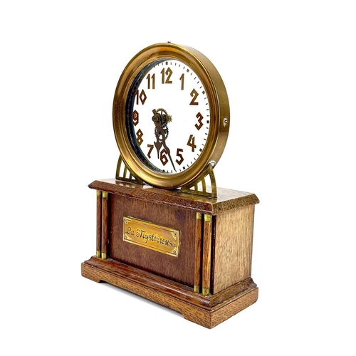 1713 - An American La Mysterieuse oak and brass cased mystery mantel clock. Circa 1910, the glass dial with... 