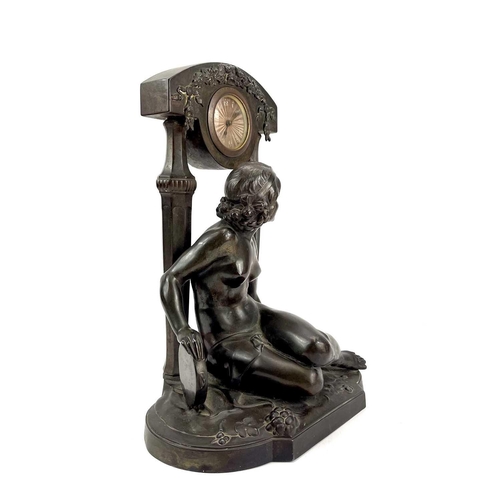 1714 - A French Art Deco spelter mantel timepiece. Modelled as a naked maiden with a tambourine before a fl... 