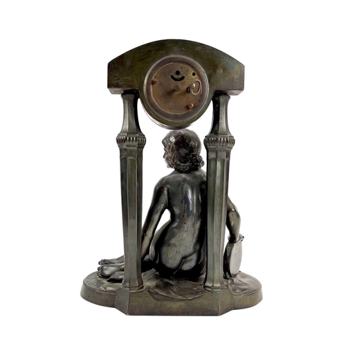 1714 - A French Art Deco spelter mantel timepiece. Modelled as a naked maiden with a tambourine before a fl... 