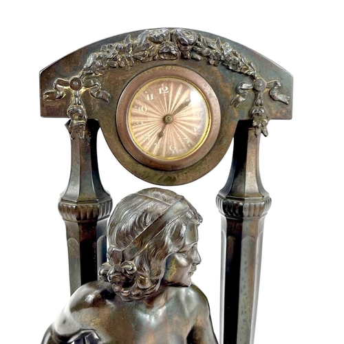 1714 - A French Art Deco spelter mantel timepiece. Modelled as a naked maiden with a tambourine before a fl... 