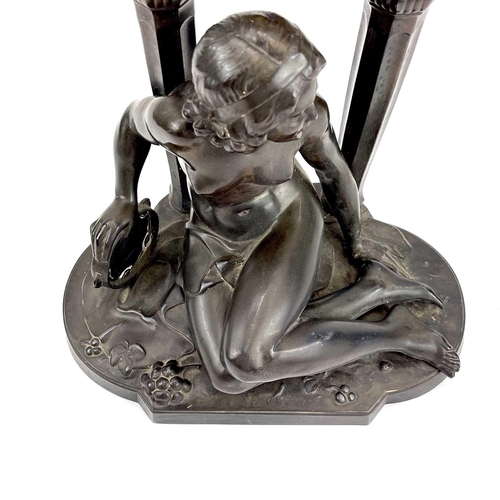 1714 - A French Art Deco spelter mantel timepiece. Modelled as a naked maiden with a tambourine before a fl... 