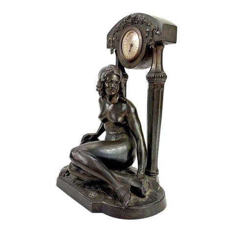 1714 - A French Art Deco spelter mantel timepiece. Modelled as a naked maiden with a tambourine before a fl... 