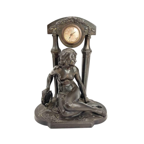 1714 - A French Art Deco spelter mantel timepiece. Modelled as a naked maiden with a tambourine before a fl... 