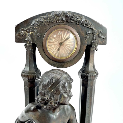 1714 - A French Art Deco spelter mantel timepiece. Modelled as a naked maiden with a tambourine before a fl... 