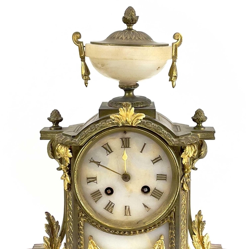 1718 - A French gilt metal and alabaster eight day mantel clock. In the Neo-Classical taste, with urn finia... 