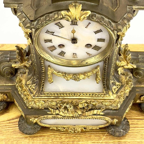 1718 - A French gilt metal and alabaster eight day mantel clock. In the Neo-Classical taste, with urn finia... 