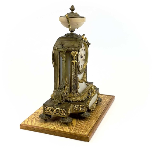 1718 - A French gilt metal and alabaster eight day mantel clock. In the Neo-Classical taste, with urn finia... 