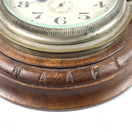 1721 - A Swiss eight-day car clock. The later turned walnut mount inscribed NAAFI, total diameter 14cm.