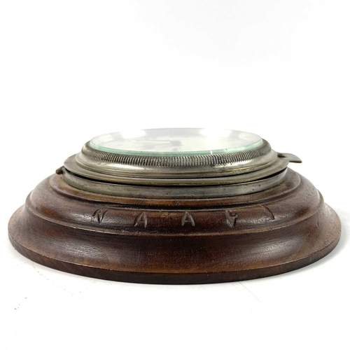 1721 - A Swiss eight-day car clock. The later turned walnut mount inscribed NAAFI, total diameter 14cm.