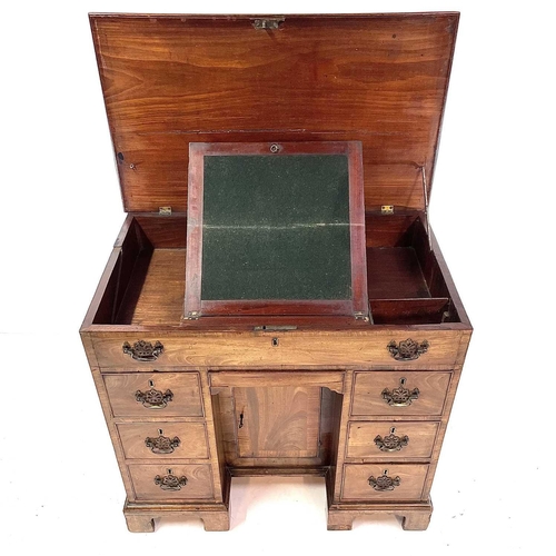 1802 - A George III mahogany kneehole gentleman's dressing table/writing desk. The rising top containing co... 