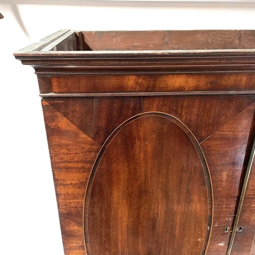 1836 - A George III mahogany linen press. The upper part with two oval panel doors enclosing sliding shelve... 