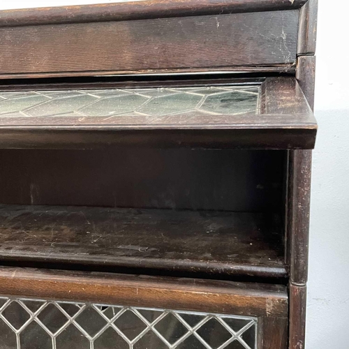 1860 - An oak glazed four part sectional bookcase. 2nd quarter 20th century, with lead glazed rising doors,... 