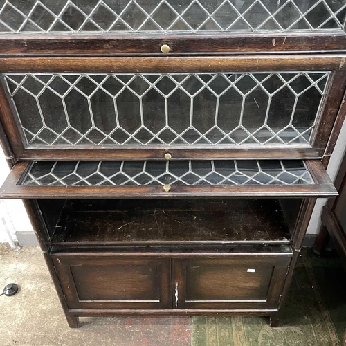 1860 - An oak glazed four part sectional bookcase. 2nd quarter 20th century, with lead glazed rising doors,... 