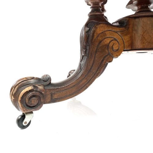 1868 - A mid Victorian walnut oval Loo table. Raised on quadruple turned supports with foliate carved legs ... 