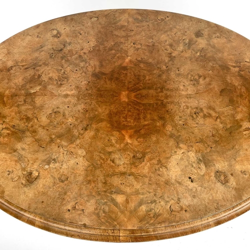 1868 - A mid Victorian walnut oval Loo table. Raised on quadruple turned supports with foliate carved legs ... 