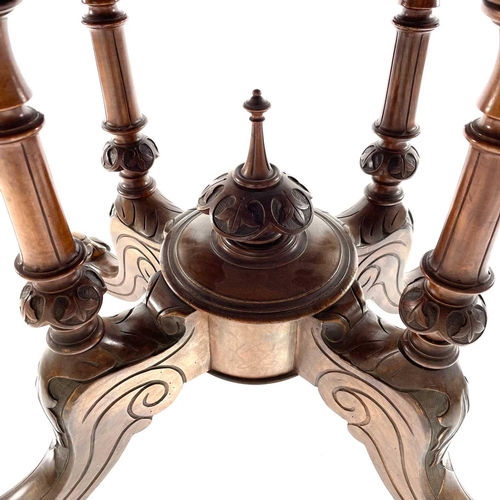 1868 - A mid Victorian walnut oval Loo table. Raised on quadruple turned supports with foliate carved legs ... 