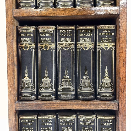 1877 - The works of Charles Dickens contained in a small oak bookcase. Fifteen volumes on three shelves, he... 