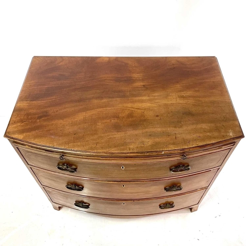 1882 - A late George III mahogany bow front chest. With ebony and boxwood stringing and fitted three crossb... 