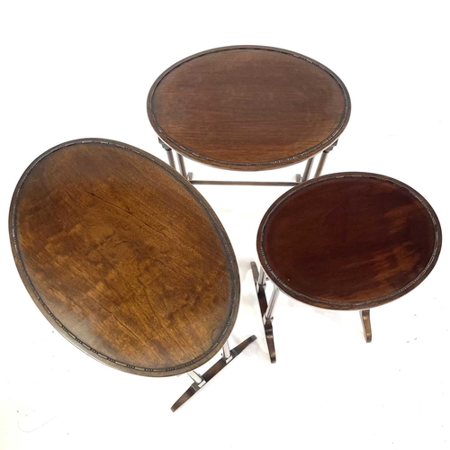 1884 - An Edwardian mahogany nest of three oval occasional tables. Raised on turned legs, the largest heigh... 