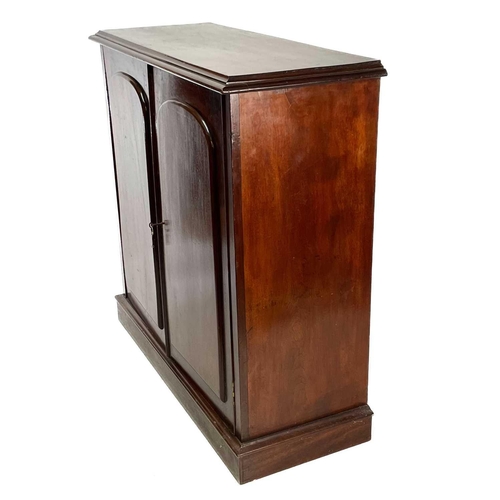 1886 - A Victorian mahogany cupboard. Fitted two arch panel doors enclosing shelves, on a plinth base, heig... 