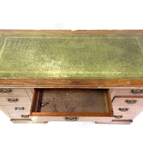 1890 - An Edwardian walnut kneehole desk. With tooled green leather skiver above one long and eight short d... 